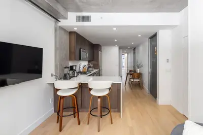 a kitchen with two bar stools and a counter top at Stunning Penthouse in Chelsea in New York
