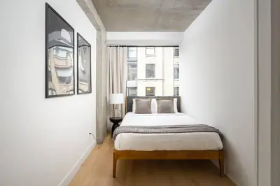 a white bedroom with a bed and a window at Stunning Penthouse in Chelsea in New York