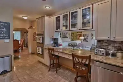 a kitchen with white cabinets and a table and chairs at Cheerful 5-bedroom resort with heated pool in East Stroudsburg