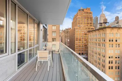 a balcony with a table and a view of a city at Synergy Chelsea in New York