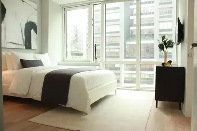 a bedroom with a large bed and a large window at Synergy Chelsea in New York