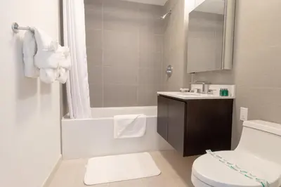 a bathroom with a toilet and a tub and a sink at Synergy Chelsea in New York