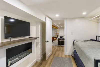 a bedroom with a large flat screen tv on a wall at Jersey City Vacation Rental Near Light Rail! in Jersey City
