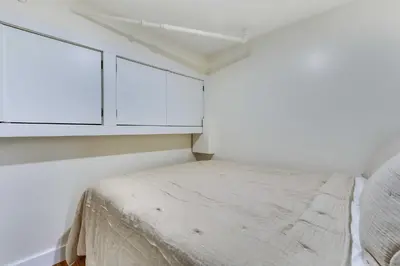 a small bedroom with white cabinets and a bed at Jersey City Vacation Rental Near Light Rail! in Jersey City