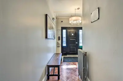 a hallway with a wooden table in front of a door at Jersey City Vacation Rental Near Light Rail! in Jersey City