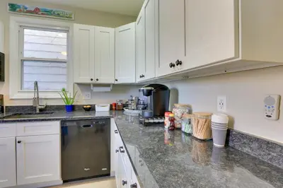 a kitchen with white cabinets and a counter top at Jersey City Apartment Near Liberty State Park in Jersey City