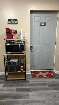 a kitchen with a door and a microwave on a cart at The McNeil Mansions in Harrisburg