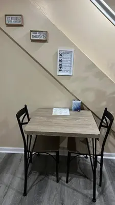 a wooden table with a bench under a stairs at The McNeil Mansions in Harrisburg