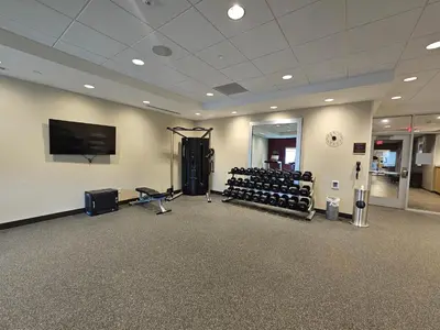 a large room with a gym with a flat screen tv at Home2 Suites By Hilton Allentown Bethlehem Airport in Bethlehem