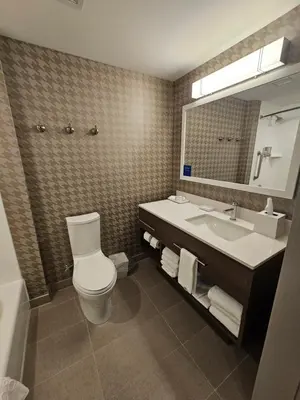 a bathroom with a toilet and a sink and a mirror at Home2 Suites By Hilton Allentown Bethlehem Airport in Bethlehem