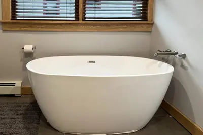 a white bath tub in a bathroom with a window at Hÿgge House in Margaretville