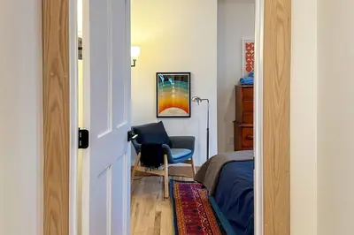 a room with a bedroom with a chair and a bed at Hÿgge House in Margaretville