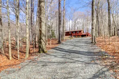 a road leading to a cabin in the woods at Pet-Friendly Home with Deck at Big Bass Lake! in Gouldsboro