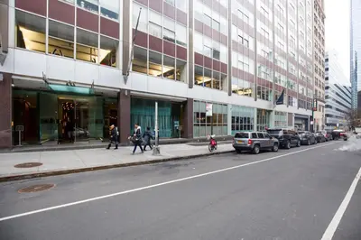 a city street with cars parked in front of a building at Tribeca 1BR w Gym Doorman Valet NYC-51 in New York