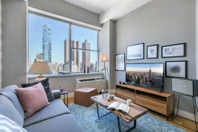 a living room with a couch and a large window at Tribeca 1BR w Gym Doorman Valet NYC-51 in New York