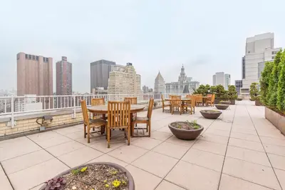a patio with tables and chairs on a roof at Tribeca 1BR w Gym Doorman Valet NYC-51 in New York