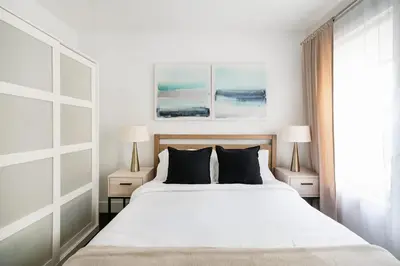 a bedroom with a white bed with two lamps at 39-2 Renovated 3BR Prime Hudson Yards Area in New York