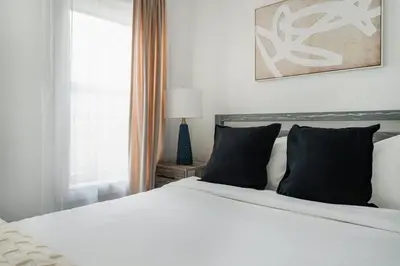 a white bed with black pillows in a bedroom at 39-2 Renovated 3BR Prime Hudson Yards Area in New York
