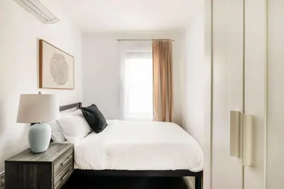 a white bedroom with a bed and a window at 39-2 Renovated 3BR Prime Hudson Yards Area in New York