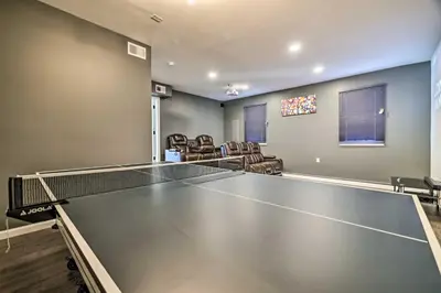 a ping pong table in a room with chairs at Movie Room, Hot Tub Pocono Vacation Rental! in East Stroudsburg