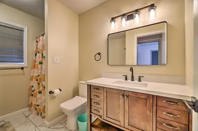 a bathroom with a sink and a mirror and a toilet at Movie Room, Hot Tub Pocono Vacation Rental! in East Stroudsburg