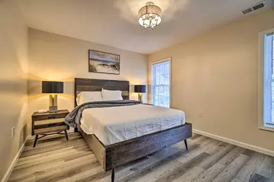 a bedroom with a large bed and two windows at Movie Room, Hot Tub Pocono Vacation Rental! in East Stroudsburg