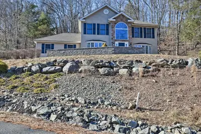 a house with a bunch of rocks in front of it at Movie Room, Hot Tub Pocono Vacation Rental! in East Stroudsburg