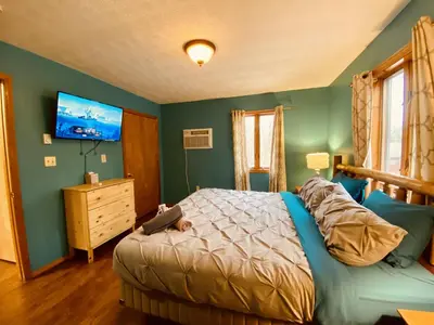 a bedroom with a bed and a tv on the wall at Knoll by the Lake-7 minutes to skiing in Lake Harmony