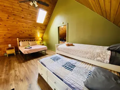 a bedroom with two beds in a log cabin at Knoll by the Lake-7 minutes to skiing in Lake Harmony