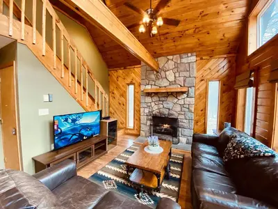 a living room with a leather couch and a fireplace at Knoll by the Lake-7 minutes to skiing in Lake Harmony