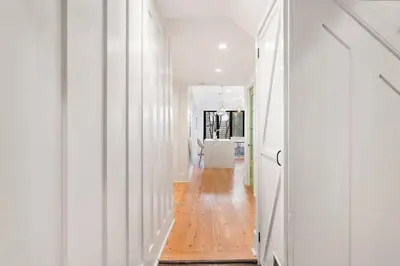 a hallway with white walls and a wooden floor at Designer 3 BR Townhome with Beautiful Backyard in Philadelphia