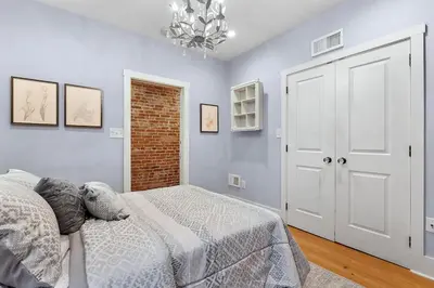 a bedroom with a bed and a brick wall at Designer 3 BR Townhome with Beautiful Backyard in Philadelphia