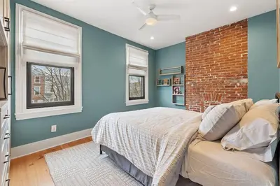 a bedroom with a bed and a brick wall at Designer 3 BR Townhome with Beautiful Backyard in Philadelphia