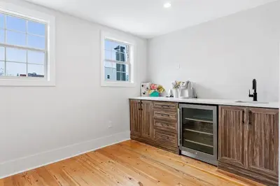 an empty kitchen with wooden cabinets and a window at Designer 3 BR Townhome with Beautiful Backyard in Philadelphia