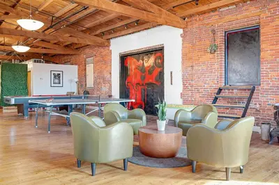 a room with a ping pong table and chairs and a brick wall at World Cup 2026 Luxury Industrial Loft in Philadelphia