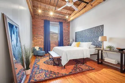 a bedroom with a white bed and a brick wall at World Cup 2026 Luxury Industrial Loft in Philadelphia