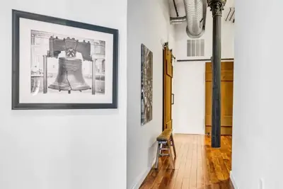 a hallway with a picture of a dress on a wall at The Independence Suite Residence in Philadelphia