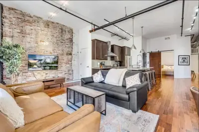 a living room with a brick wall and a couch at The Independence Suite Residence in Philadelphia