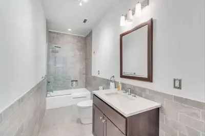 a bathroom with a sink and a toilet and a mirror at The Independence Suite Residence in Philadelphia
