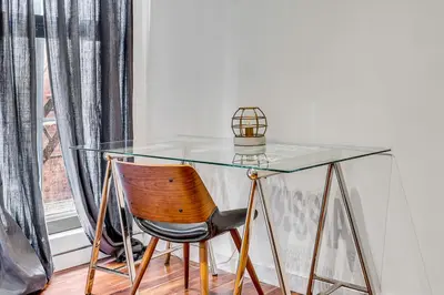 a glass table with a chair next to a window at The Founders Suite Residence in Philadelphia