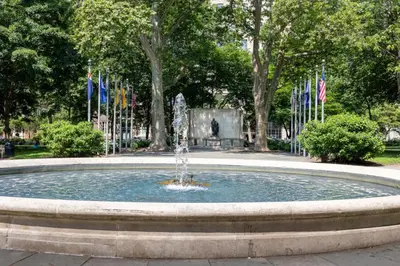 a fountain in a park with flags in the background at The Founders Suite Residence in Philadelphia