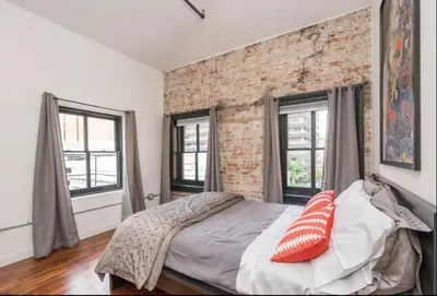 a bedroom with a brick wall and a bed with pillows at The Liberty Suite Residence in Philadelphia