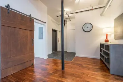 an open room with a large wooden door and a clock at The Liberty Suite Residence in Philadelphia