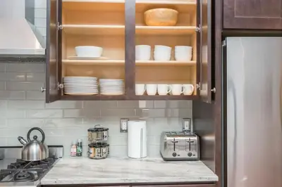 a kitchen counter with a refrigerator and some dishes at The Liberty Suite Residence in Philadelphia