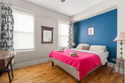 a bedroom with blue walls and a bed with a pink blanket at Fairmount Neighborhood Gem in Philadelphia