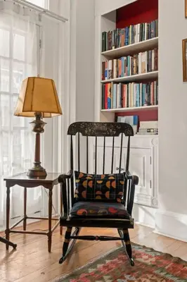 a chair and a lamp in a room with a book shelf at Fairmount Neighborhood Gem in Philadelphia