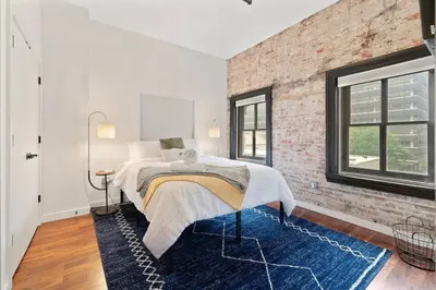 a bedroom with a bed and a brick wall at The Heritage Suite Central Old City Near the Liberty Bell in Philadelphia