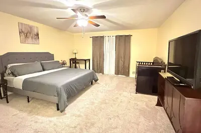 a bedroom with a bed and a flat screen tv at Modern 5 Bedroom Pocono house - Jacuzzi - Gameroom - Near Lake - Golf Couse in Tobyhanna