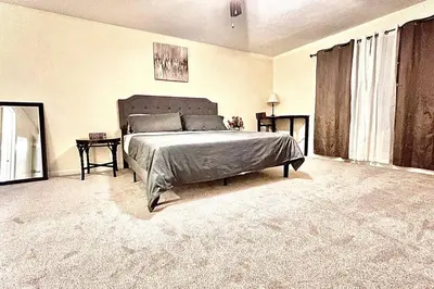 a bedroom with a large bed and a large window at Modern 5 Bedroom Pocono house - Jacuzzi - Gameroom - Near Lake - Golf Couse in Tobyhanna