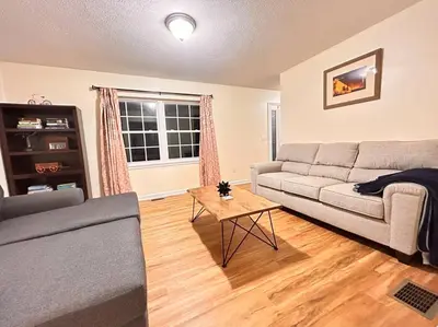 a living room with a couch and a table at Modern 5 Bedroom Pocono house - Jacuzzi - Gameroom - Near Lake - Golf Couse in Tobyhanna